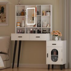 a white desk with drawers and a mirror on top of it next to a couch