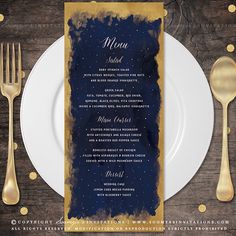 a menu card with gold foil on it next to a white plate and silverware