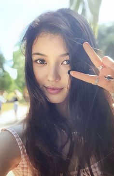 a woman holding her hand up to the camera