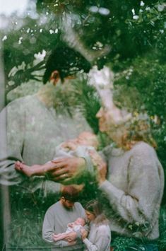 two people and a baby are standing in the grass