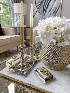 a vase with flowers and candles on a table in a living room or dining room