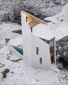 an aerial view of a house in the middle of snow covered ground with stairs leading up to it