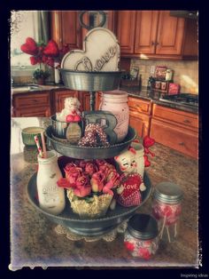 a three tiered tray filled with assorted items on top of a kitchen counter