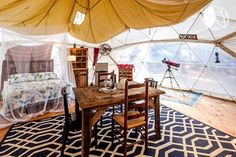 the inside of a tent with a table and chairs