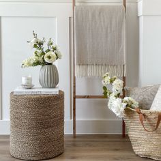 two baskets with flowers in them sitting on the floor next to a chair and towel rack