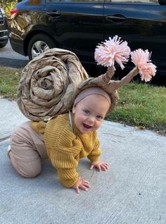 a baby in a costume is crawling on the sidewalk