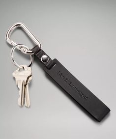 a black leather keychain with two keys attached to the front and back of it