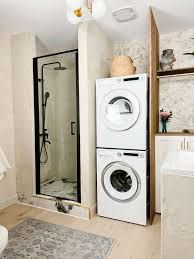 a washer and dryer in a small room with a toilet, sink, and shower