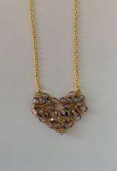 beaded pendant pale pink heart pendant pink fire polished crystals gold seed beads heart shape bling pendant gold chain This is a beaded pendant in pale pink earth tone type colours. This is a  heart pendant, made from pink fire polished crystals, woven into circles and edged using gold seed beads to create  heart shape. The cut on the crystals makes this a  bling pendant. The pendant is strung on a gold chain, with a lobster clasp completing it. Heart-shaped Faceted Beads Necklace For Jewelry Making, Gold Crystal Heart Necklace, Heart-shaped Faceted Beads Necklace For Gift, Heart-shaped Crystal Beaded Jewelry, Pink Heart Pendant Beaded Necklace For Valentine's Day, Heart-shaped Necklace With Faceted Beads For Gift, Gold Heart-shaped Jewelry With Faceted Beads, Pink Beaded Heart Pendant Necklace, Gold Beaded Necklaces With Heart Charm And Round Beads