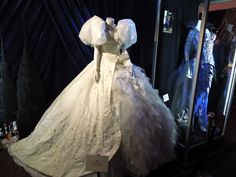 a white wedding dress on display in front of a mirror