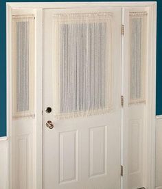 an open white door with sheer curtains on the top and bottom panels, in front of a blue wall