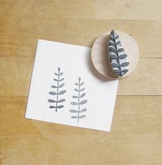 a rubber stamp with leaves on it next to a piece of paper that has been printed onto