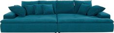 a blue couch with lots of pillows sitting on it's back legs and arms