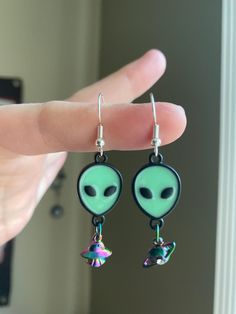 Alien earrings with UFO and planet charms in either gold colored, silver colored, or multicolored.  I use silver plated ear hooks for anyone with sensitive ears. Alien Earrings, Green Alien, Ear Hook, Sensitive Ears, Jewelry Earrings Dangle, Gold Color, Etsy Earrings, Silver Plated, Dangle Drop Earrings