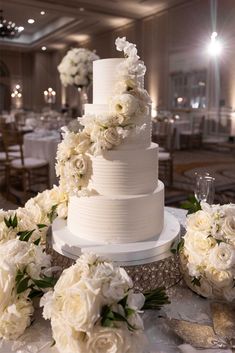 a wedding cake with white flowers on the table