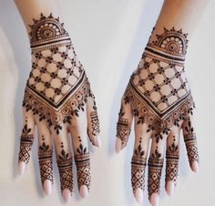 two hands with henna designs on them, one is black and the other is white