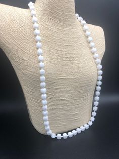 a white beaded necklace on a mannequin