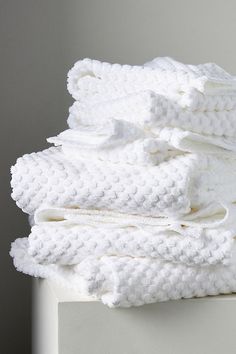 stack of folded white towels sitting on top of each other