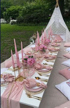 the table is set with pink napkins and place settings for an elegant dinner party