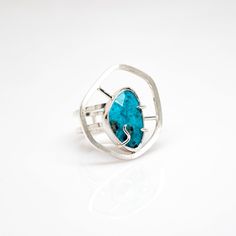 The Tranquility Turquoise Ring emits a peaceful and meditative quality. The American Turquoise focal point is known to be a "stone of the ancients." The ancients believed in the stone's power to protect. It also represents tranquility and good fortune among many spiritual attributes. A beautiful structural ring that entices meaningful conversation and contemplation. One-of-a-Kind Size 7. Unavailable for resize. Sterling Silver Rosecut American Turquoise To get your ring size, click here for our Spiritual Sterling Silver Turquoise Ring With Large Stone, Modern Turquoise Round Ring, Modern Turquoise Ring As Gift, Modern Turquoise Ring For Gift, Modern Turquoise Ring For A Gift, Spiritual Turquoise Ring For Healing, Turquoise Apatite Rings For Gift, Faceted Apatite Turquoise Jewelry, Gift Turquoise Apatite Rings