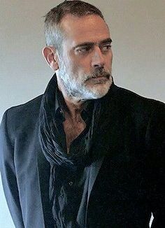 a man in a black suit and scarf