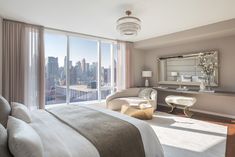 a bedroom with a large window overlooking the city