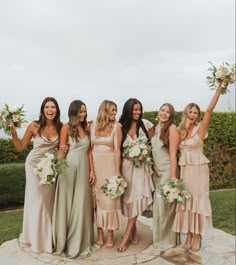 a group of women standing next to each other holding bouquets