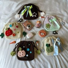 several crocheted purses are laying on a bed with buttons and pins attached to them