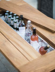 an open wooden box filled with bottles of alcohol