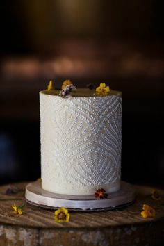 a white wedding cake with yellow flowers on top