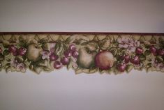 a wall hanging with fruit and flowers on it