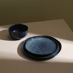 two blue bowls sitting on top of a table