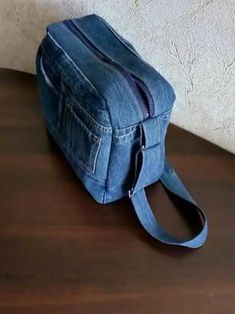 a denim bag sitting on top of a wooden table