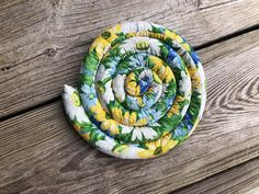 three pieces of fabric sitting on top of a wooden table next to an object that looks like a flower