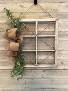 an old window is decorated with burlock and greenery for the holiday season