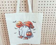 a white bag with an image of a ghost holding two pumpkins