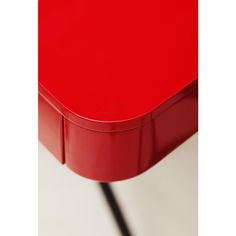 a red table that is sitting on a white surface with a black cord attached to it