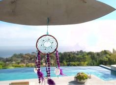 a wind chime hanging from the side of a building next to a swimming pool