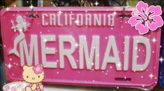 a pink license plate that says california mermaid with a hello kitty image on the front