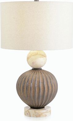 a table lamp with a marble base and a white linen shade on the top of it