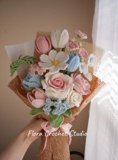 a person holding a bouquet of flowers in front of a window