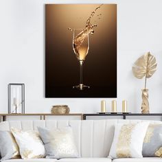 champagne being poured into a wine glass in a living room with gold pillows and throw pillows