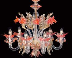 a chandelier with many lights and flowers on the bottom one light is red