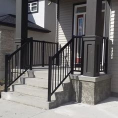 the front porch and stairs of a house with black iron railings on both sides