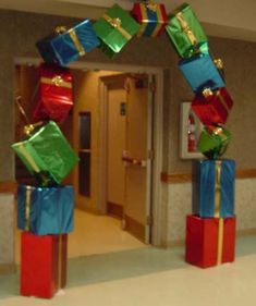 several presents are stacked on top of each other in front of an open door at the end of a hallway