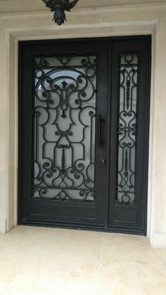 a black double door with intricate iron work on the front and side doors that lead into an entrance