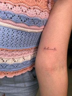 a woman's arm with a small tattoo on the left side of her arm