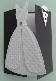 an origami wedding dress and tuxedo are on display in a mirror