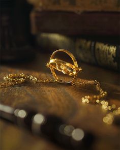 a gold necklace sitting on top of a table next to a pair of glasses and a book