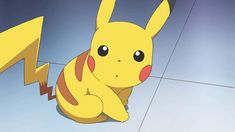 a pikachu sitting on the ground next to a lightning bolt